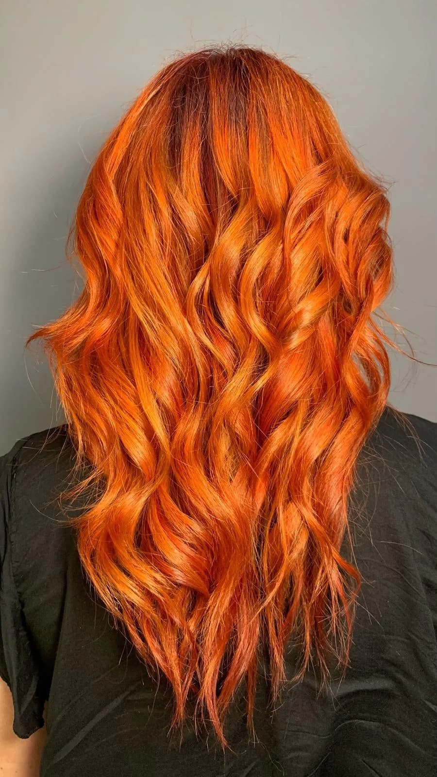 Longue chevelure rousse orangée et ondulée, vue de dos