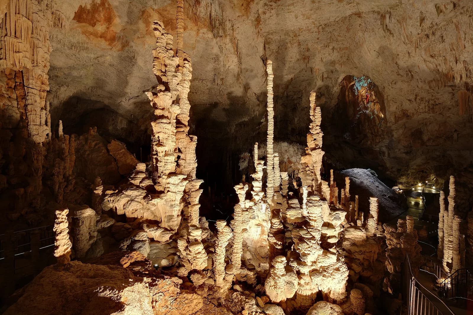 Une salle de l'aven d'Orgnac : de hautes stalagmites en piles d'assiettes éclairées sous une voûte immense